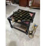 A modern games table with glass chessboard top enclosing gaming pieces; together with a fireside