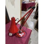 A red anglepoise lamp