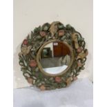 A wall mirror in the manner of Alphonse Mucha, the painted wood frame carved and pierced with