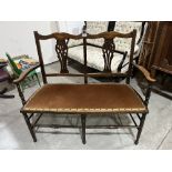 An early 20th century double chair back settee with pierced splats, on turned legs and stretchers.