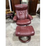 A Norwegian Ekornes stressless reclining and swivel armchair and footstool upholstered in claret