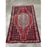 A red ground eastern carpet. 78' x 49'