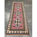 An eastern pink ground carpet runner. 108' x 42'