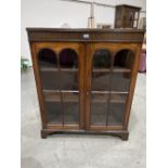 A mahogany bookcase, enclosed by a pair of arch glazed doors on bracket feet. 36' wide