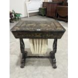 A 19th century japanned work table, the exterior and fitted interior profusely decorated with garden