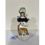 A 19th century Staffordshire figure of a lady, seated with dog and fiddle. 6¼' high