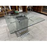 A modernist centre table, the glass top raised on a chrome plated slatted square base. 43' x 43'.