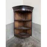 An oak and mahogany open hanging corner cupboard