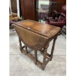 An oak gateleg table, the top with demi-lunette carved border. 30' wide