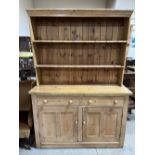 A Victorian pine dresser, the raised rack over a pair of drawers and cupboard door. 57'w x 79'h