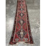 A red ground eastern carpet runner. 151' x 33'