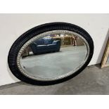 An oval wall mirror with bevelled plate. 45' x 33'