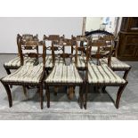 A set of seven Regency mahogany dining chairs with carved backs and brass line inlaid splats, on