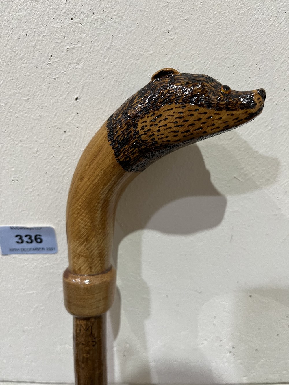 A hazel walking stick, the pommel a carved oak badger with glass eyes. 50½' long