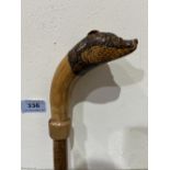 A hazel walking stick, the pommel a carved oak badger with glass eyes. 50½' long