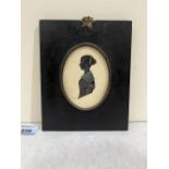 An early 19th century English silhouette miniature of a young lady wearing a lace collar. The