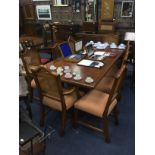 A TEAK DINING TABLE AND TEN CHAIRS