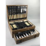 AN OAK CANTEEN OF SILVER PLATED CUTLERY