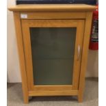 AN OAK CUPBOARD WITH GLAZED DOOR