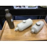 A 19TH CENTURY BRASS WATER BOTTLE AND TWO STONEWARE BOTTLES