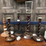 A PAIR OF MAHOGANY TURNED WOOD CANDLESTICKS AND THREE TABLE LAMPS