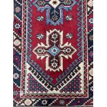 A MIDDLE EASTERN FRINGED AND BORDERED RUNNER AND A RUG