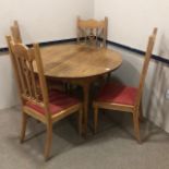 AN OAK CIRCULAR DINING TABLE AND FOUR CHAIRS