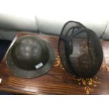 A WWII BRITISH HELMET AND A FENCING MASK