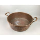 A LARGE COPPER TWIN HANDLED PAN