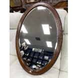 AN OVAL BEVELLED WALL MIRROR