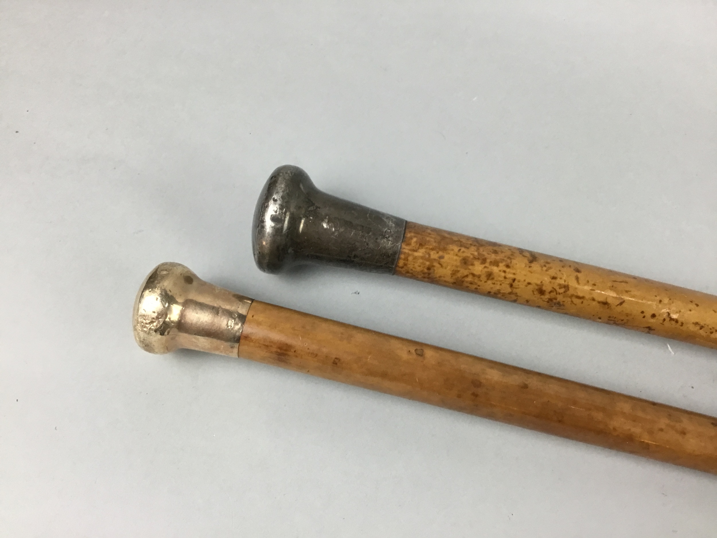A GOLD AND A SILVER TOPPED CANE