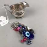 A PLATED CREAM JUG AND FOUR NOVELTY KEY RINGS