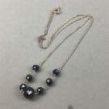 A BLACK MOISSANITE BEAD NECKLACE AND A RUBY AND BLACK MOISSANITE NECKLACE