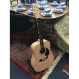 A CHILD'S PINK ACOUSTIC GUITAR ON STAND