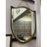 A BRASS SHIELD SHAPED WALL MIRROR