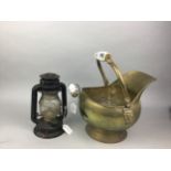 A BRASS HELMET SHAPED COAL SCUTTLE AND AN OIL LAMP