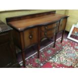 AN EDWARDIAN MAHOGANY SERPENTINE FRONTED SIDEBOARD