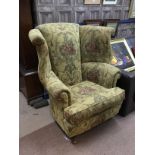 A FLORAL UPHOLSTERED WING BACK ARMCHAIR