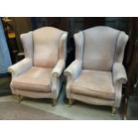 A PAIR OF UPHOLSTERED WING ARMCHAIRS