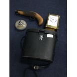 A BRASS CARRIAGE CLOCK, BINOCULARS, NOVELTY PISTOL AND A PAPERWEIGHT