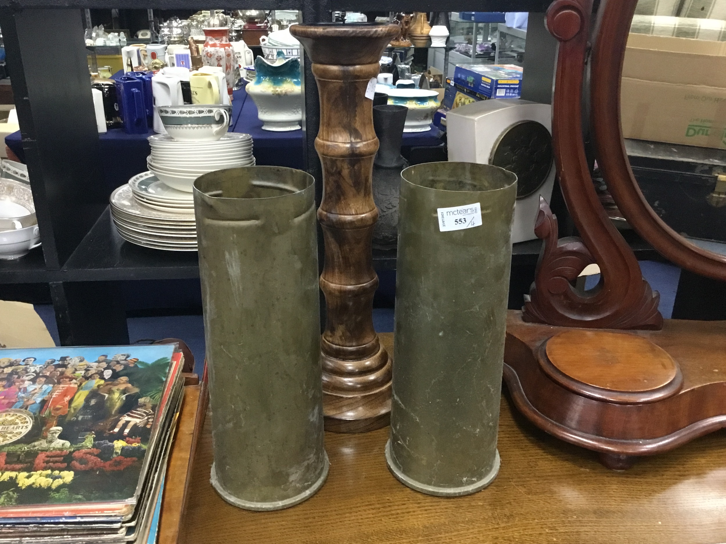 A CARVED FOLDING OCCASIONAL TABLE, TURNED WOOD CANDLESTICK AND TWO SHELL CASINGS