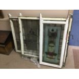 A SET OF THREE STAINED AND LEADED GLASS PANELS