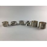A PAIR OF EARLY 20TH CENTURY SILVER ENGINE TURNED NAPKIN RINGS AND FOUR OTHER NAPKIN RINGS