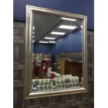 A LARGE MODERN WALL MIRROR IN A SILVERED FRAMED