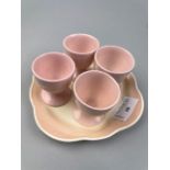 A SUSIE COOPER EGG CUP STAND AND FOUR OTHER EGG CUPS