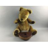 A VINTAGE MERRYTHOUGHT BLONDE PLUSH TEDDY BEAR AND A WOODEN MUSICAL INSTRUMENT