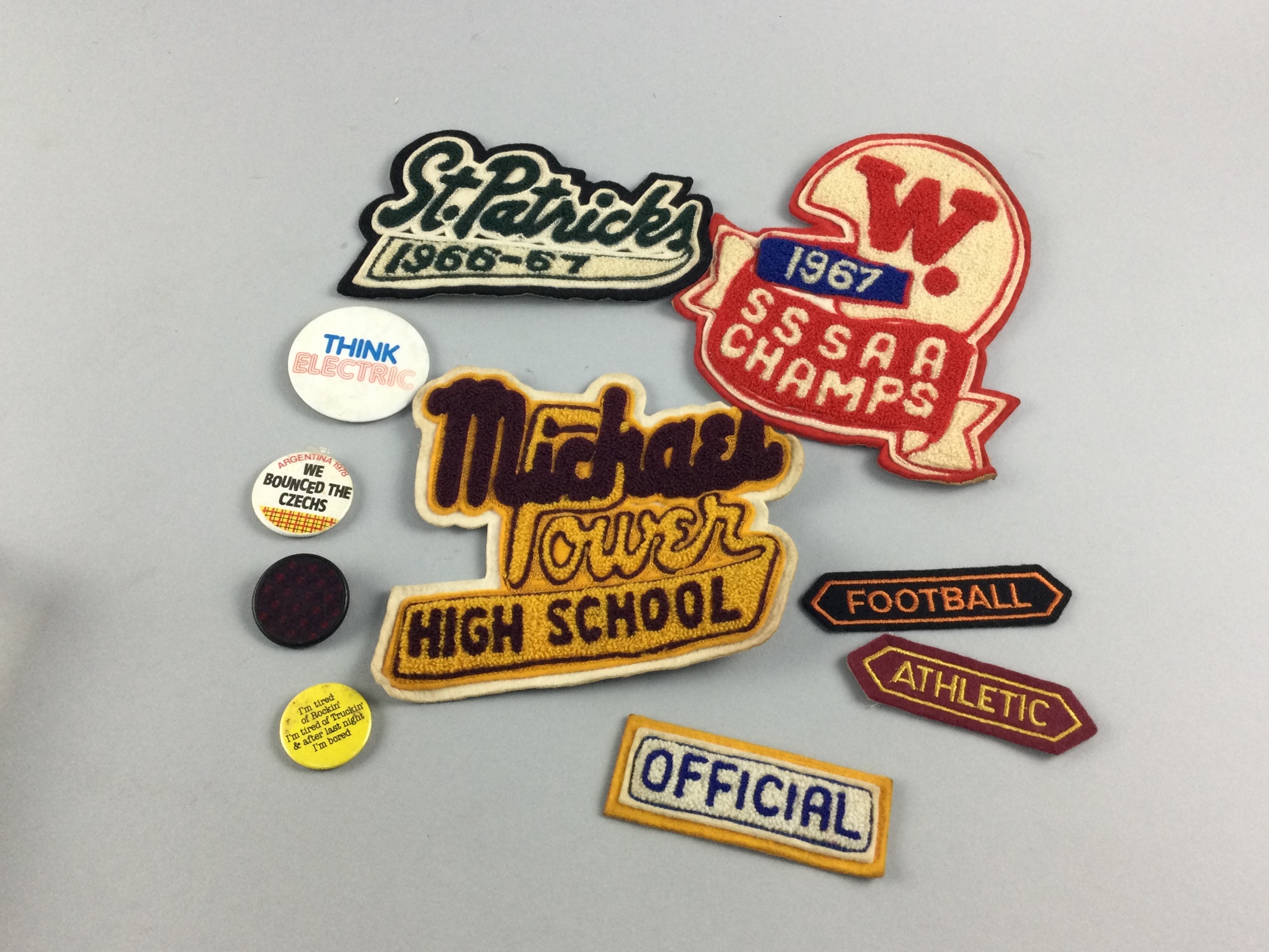 A COLLECTION OF CANADIAN 1960/70'S VARSITY EMBROIDERED PATCHES ALONG WITH 70s PINBADGES