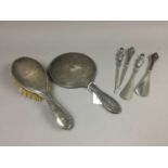 A SILVER HAND MIRROR AND BRUSH, ALONG WITH BUTTON HOOK AND SHOE HORN SETS