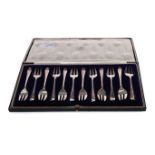 A SET OF TWELVE GEORGE V SILVER CAKE FORKS IN FITTED CASE