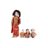 A 20TH CENTURY CHINESE BISQUE HEADED DOLL AND THREE SMALLER DOLLS